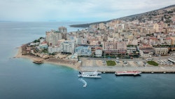 Energy Observer moored with the town of Sarande next door